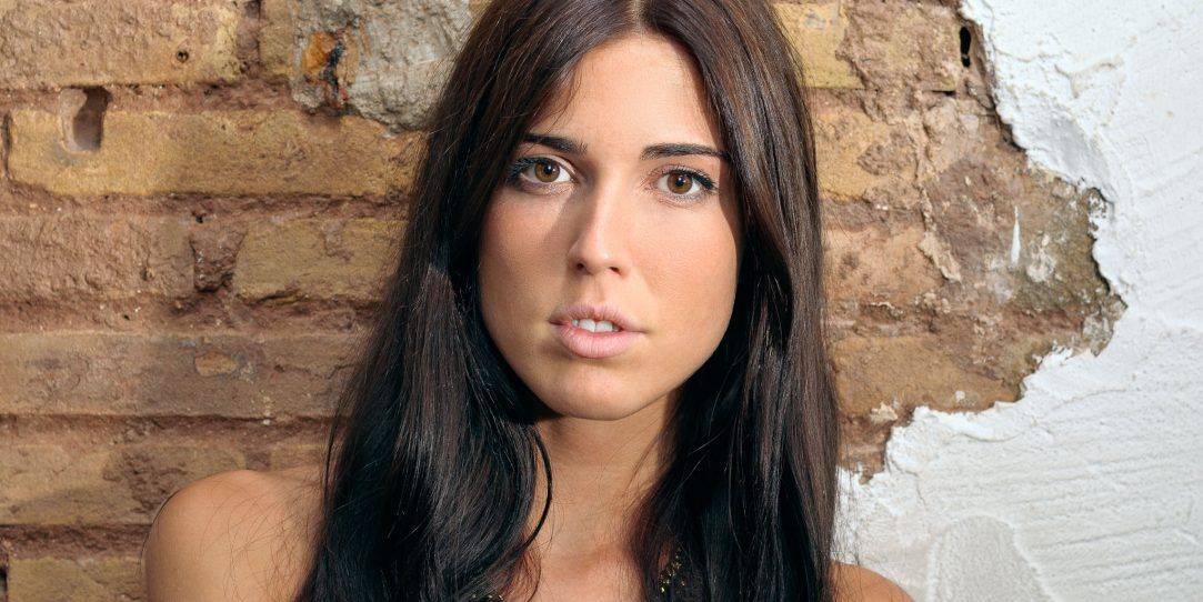 Preciosa mirada de modelo apoyada a la pared