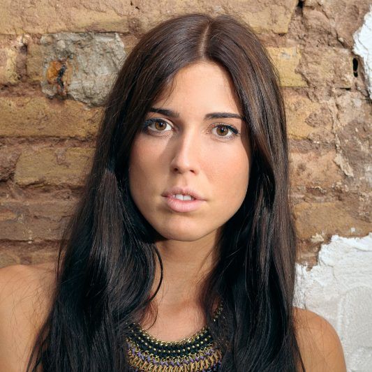 Preciosa mirada de modelo apoyada a la pared
