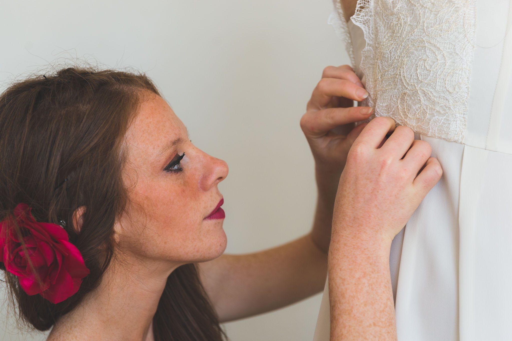Téstigo de boda ayuda la novia con el vestido